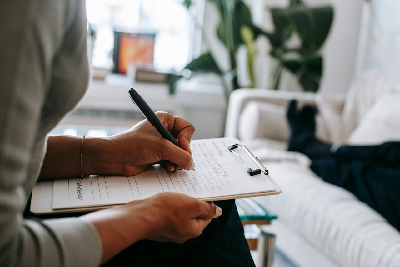 Crafting Captivating Headlines: Your awesome post title goes here Unrecognizable ethnic female therapist taking notes on clipboard while filling out form during psychological appointment with anonymous client lying on blurred background
